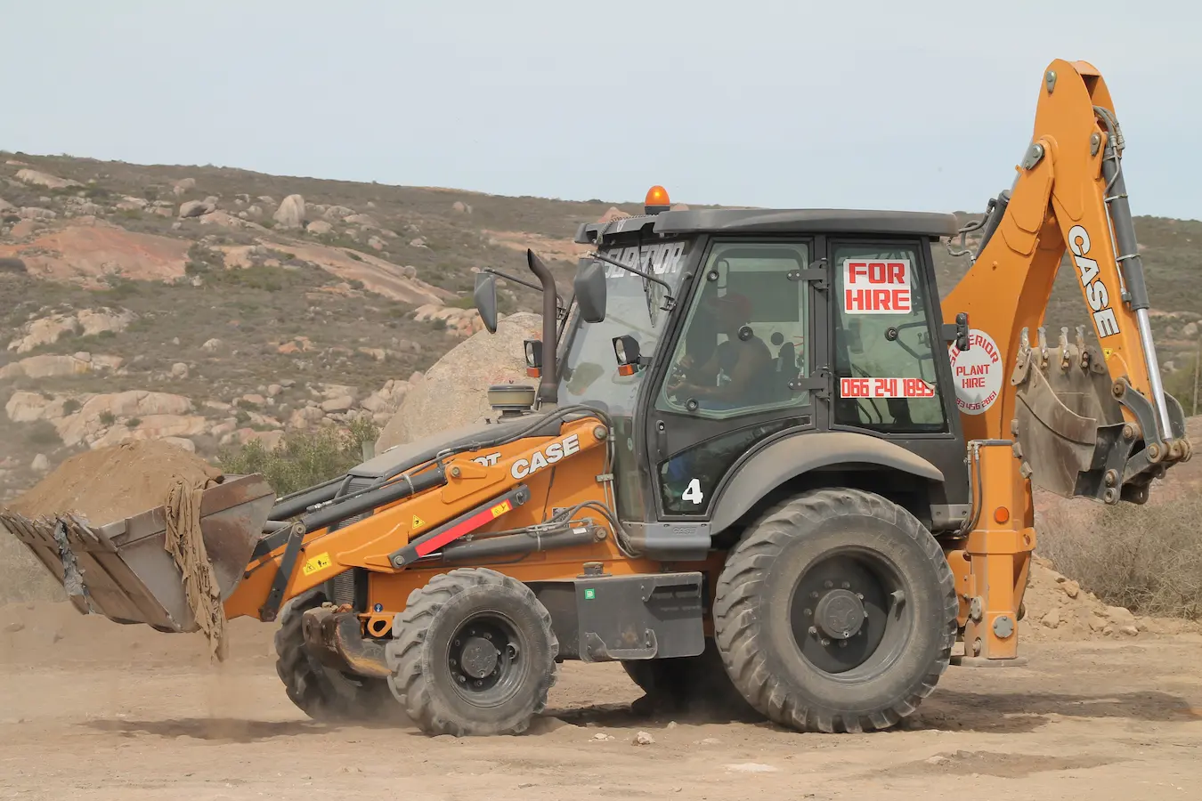 Superior Plant Hire loader driving with its bin full of rubble