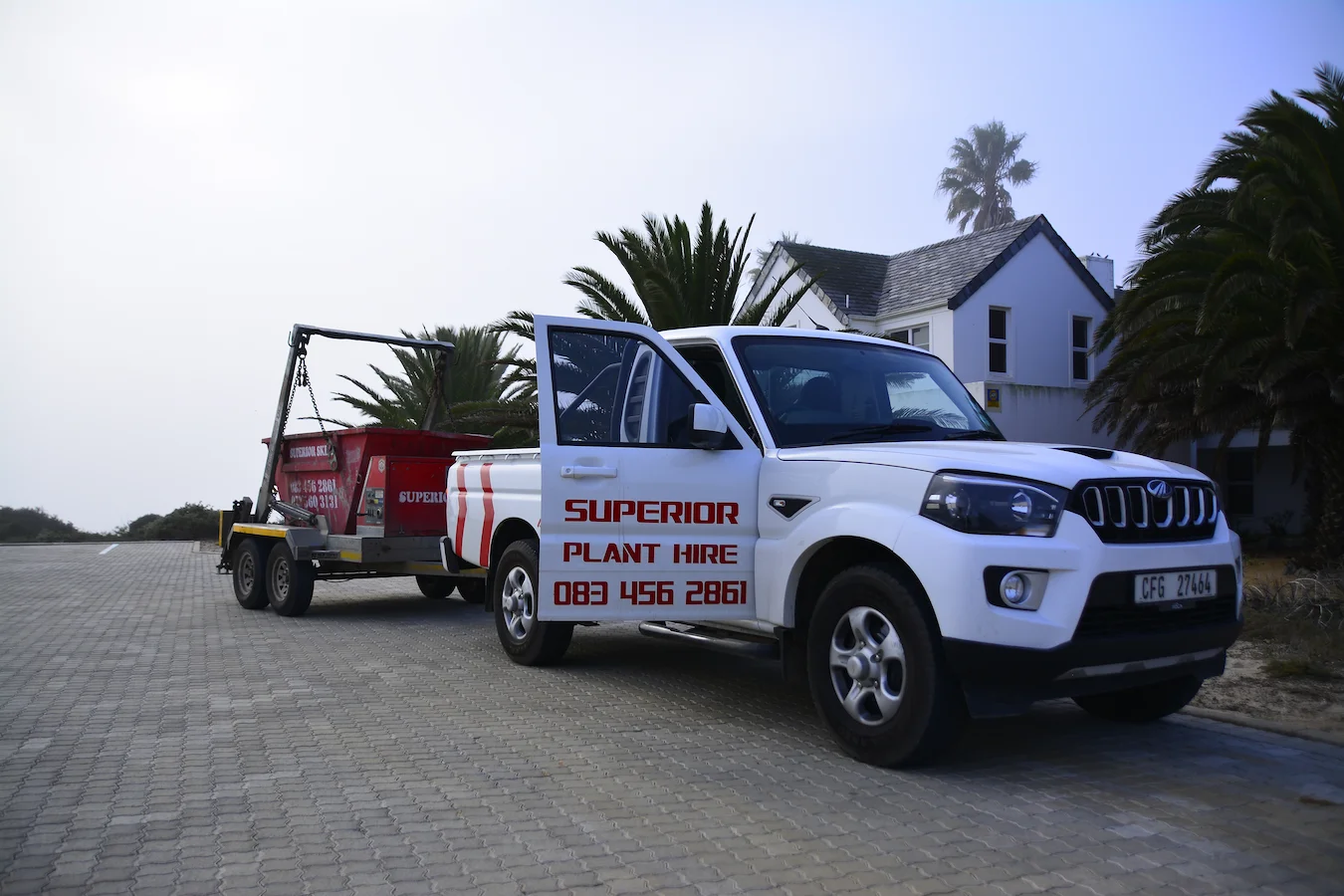 Superior Plant Hire bakkie delivering a skip on a trailer